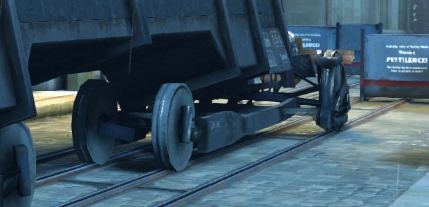 A train truck with the front wheels narrow and the rear wheels wide.